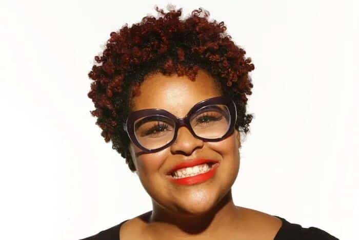 a lady smiling and having a Tapered Afro hair style