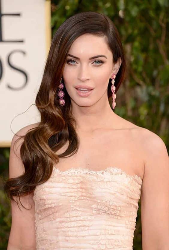 a woman wearing earrings and a Side Swept Waves hairstyle