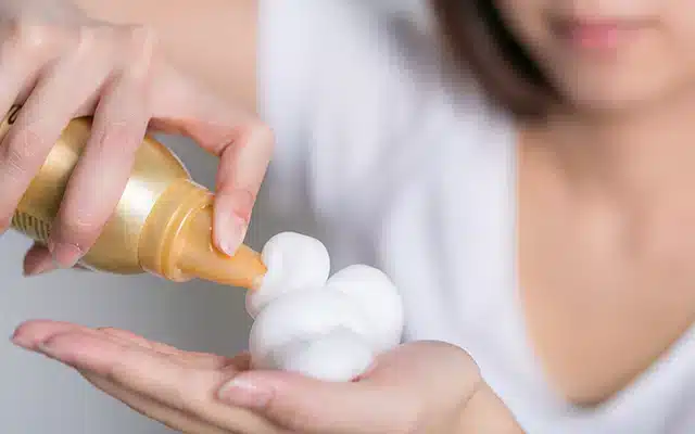 hair mousse oozed on hand from bottle