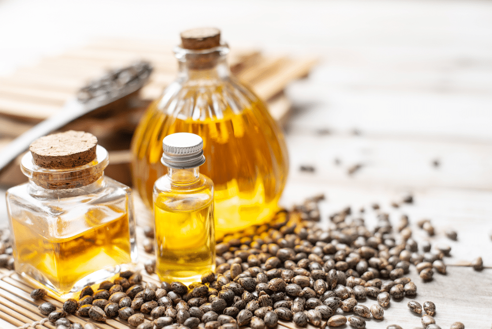 Castor oil in bottles on wooden background